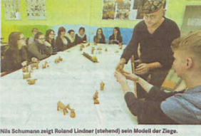 Nils Schumann zeigt Roland Lindner (stehend) sein Modell der Ziege.